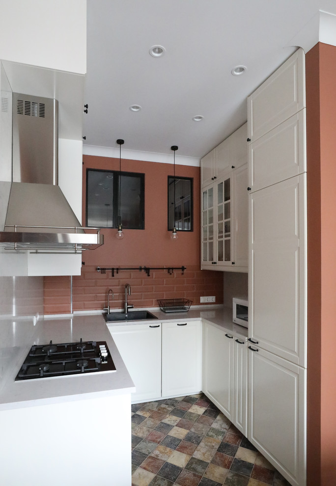 Modern inredning av ett litet vit vitt kök, med en nedsänkt diskho, vita skåp, bänkskiva i kvarts, stänkskydd i terrakottakakel, klinkergolv i keramik, flerfärgat golv, luckor med upphöjd panel, brunt stänkskydd och svarta vitvaror