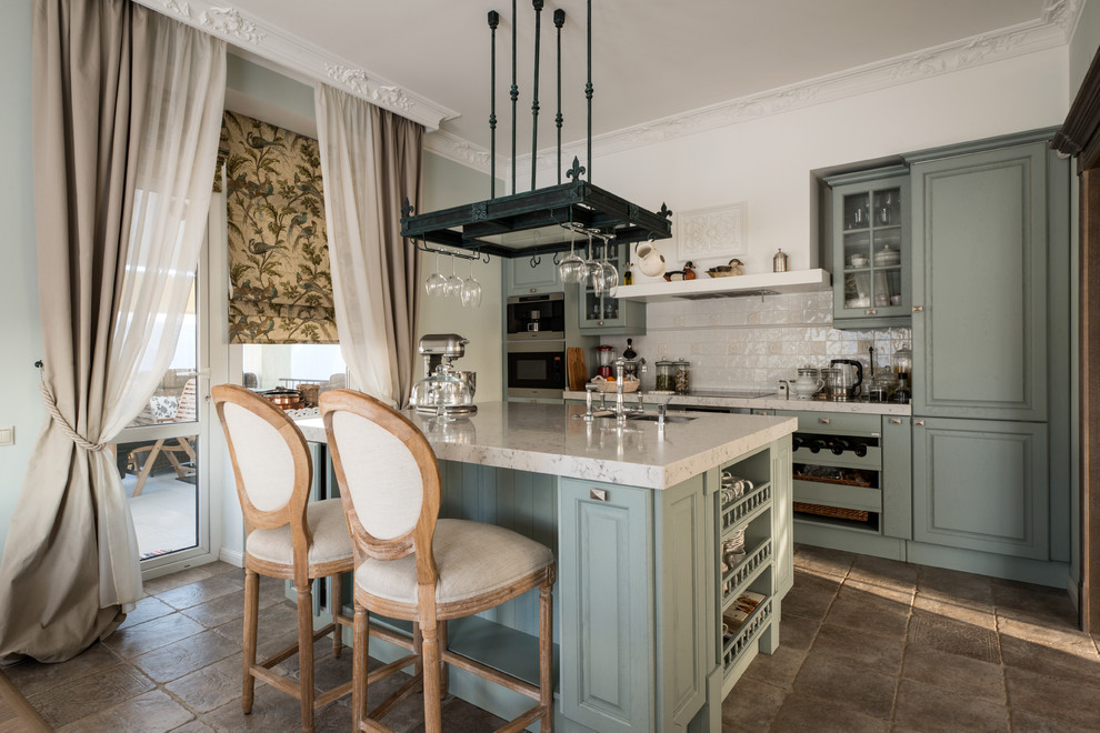 Bild på ett vintage linjärt kök och matrum, med luckor med upphöjd panel, gröna skåp, beige stänkskydd, rostfria vitvaror, en köksö och brunt golv