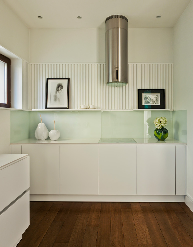 Esempio di una cucina design con ante lisce, ante bianche, paraspruzzi bianco, paraspruzzi con lastra di vetro, parquet scuro e pavimento marrone