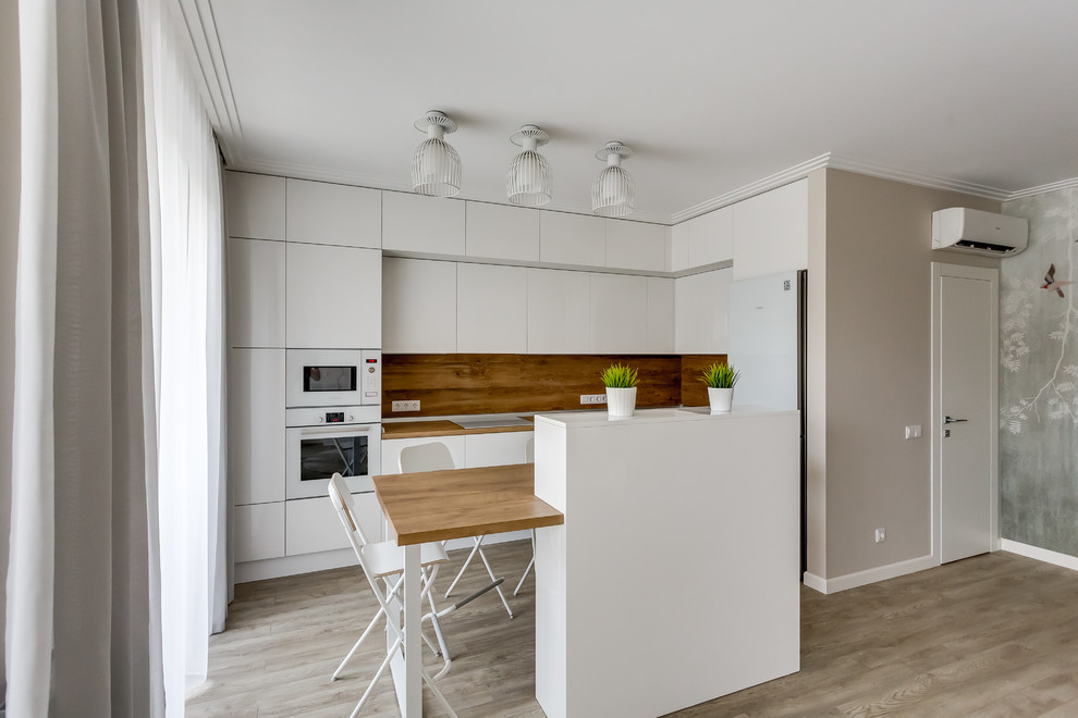 Идея дизайна: кухня среднего размера, со шкафом над холодильником в современном стиле