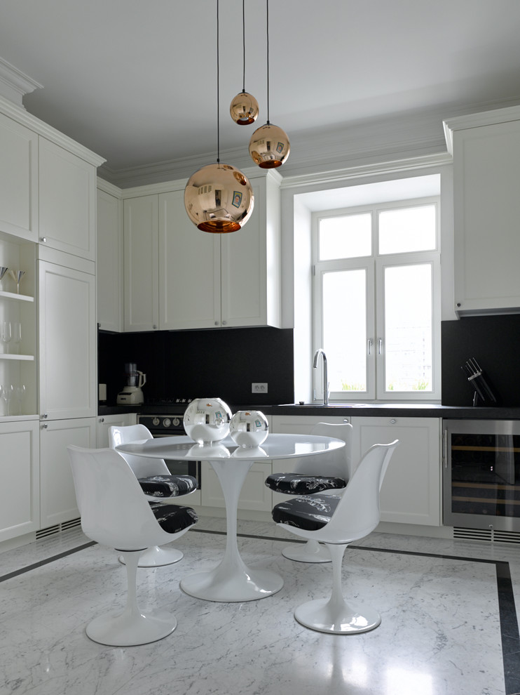 Diseño de cocinas en L contemporánea sin isla con armarios con paneles empotrados, puertas de armario blancas, salpicadero negro, suelo gris y encimeras negras