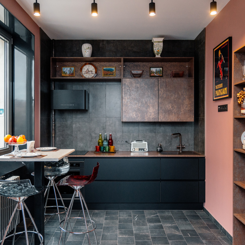 Immagine di una piccola cucina ad U industriale chiusa con ante lisce, ante nere, paraspruzzi grigio, paraspruzzi in gres porcellanato e nessuna isola