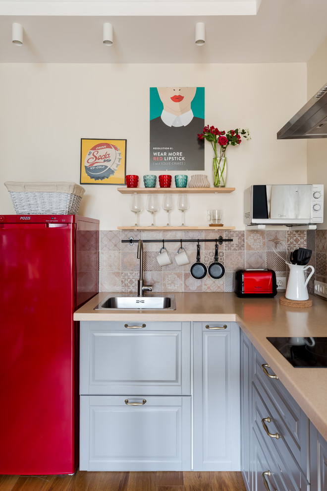 Design ideas for a small eclectic l-shaped kitchen in Saint Petersburg with a built-in sink, raised-panel cabinets, grey cabinets, composite countertops, ceramic splashback, coloured appliances, laminate floors, beige worktops, multi-coloured splashback and a feature wall.