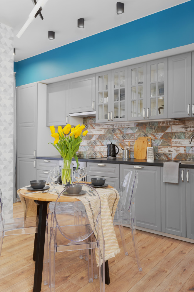 Esempio di una piccola cucina lineare contemporanea con ante con bugna sagomata, ante grigie, paraspruzzi multicolore, parquet chiaro, nessuna isola, pavimento beige e top grigio