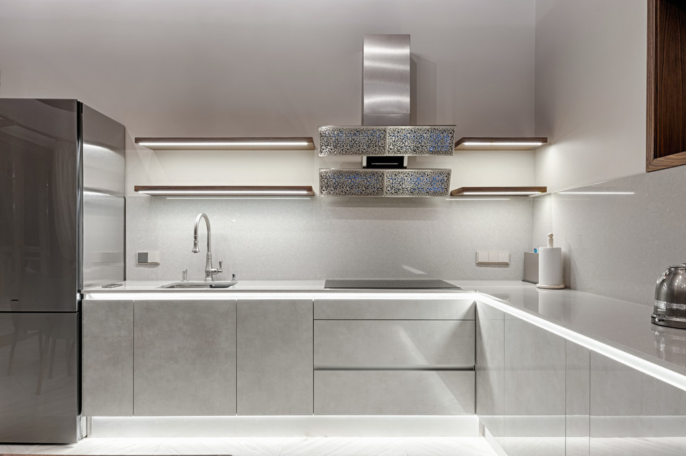 Esempio di una cucina a L design con lavello sottopiano, ante lisce, ante grigie, paraspruzzi grigio e top grigio