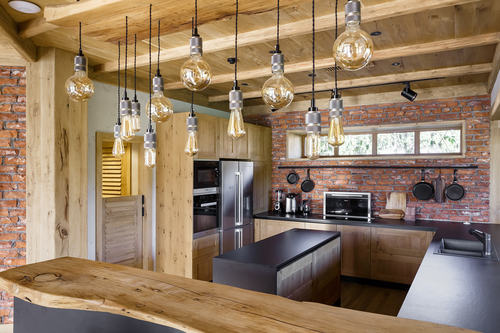 Источник вдохновения для домашнего уюта: п-образная кухня в стиле лофт с накладной мойкой, фасадами в стиле шейкер, светлыми деревянными фасадами, островом и черной столешницей