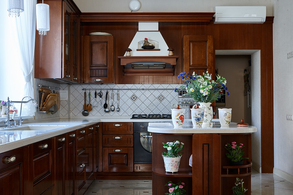 Свежая идея для дизайна: кухня в классическом стиле с врезной мойкой, фасадами цвета дерева среднего тона, белым фартуком, черной техникой и островом в частном доме - отличное фото интерьера