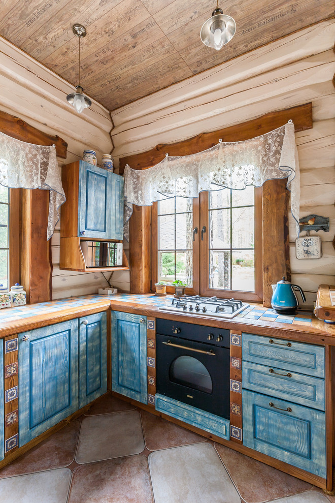 Exempel på ett shabby chic-inspirerat u-kök, med en nedsänkt diskho, luckor med upphöjd panel, blå skåp, kaklad bänkskiva och en halv köksö