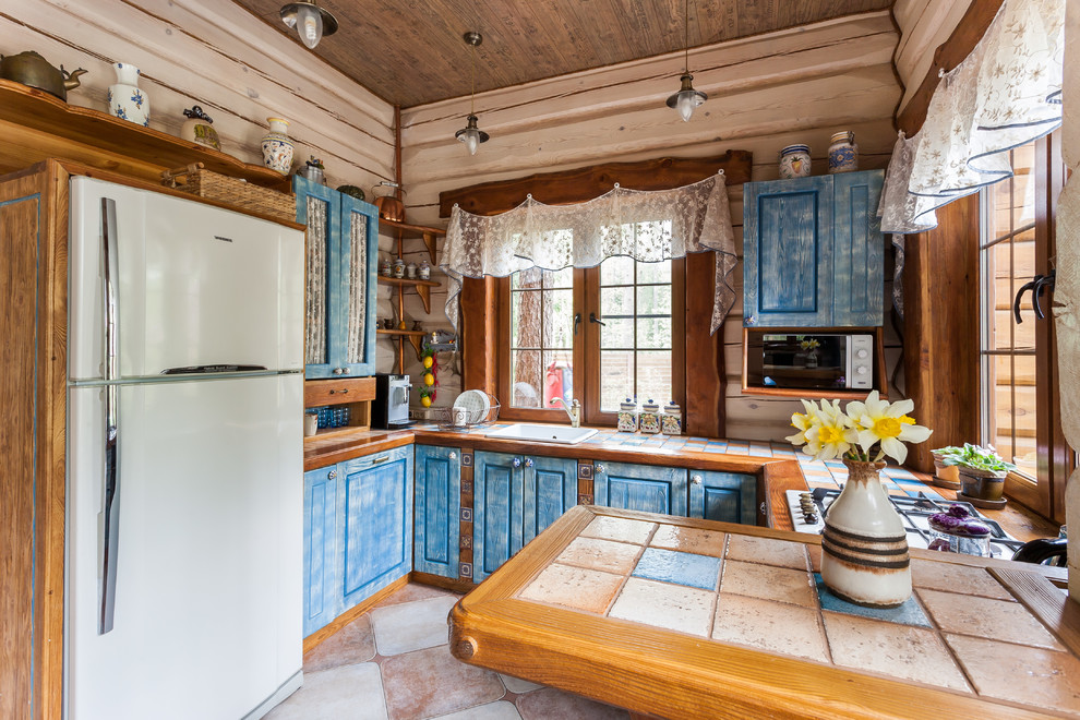 Idéer för att renovera ett rustikt u-kök, med en nedsänkt diskho, luckor med upphöjd panel, blå skåp, en halv köksö och kaklad bänkskiva