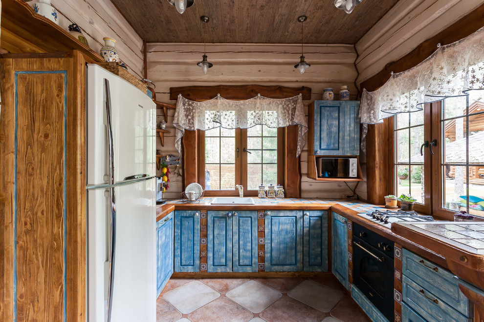 Inspiration för ett shabby chic-inspirerat u-kök, med en nedsänkt diskho, luckor med upphöjd panel, blå skåp, kaklad bänkskiva och en halv köksö