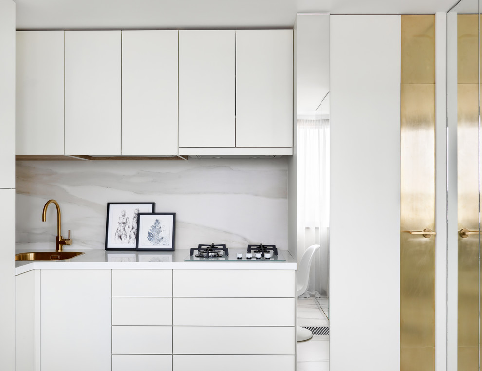 Идея дизайна: угловая кухня в современном стиле с накладной мойкой, плоскими фасадами, белыми фасадами, белым фартуком и белой столешницей