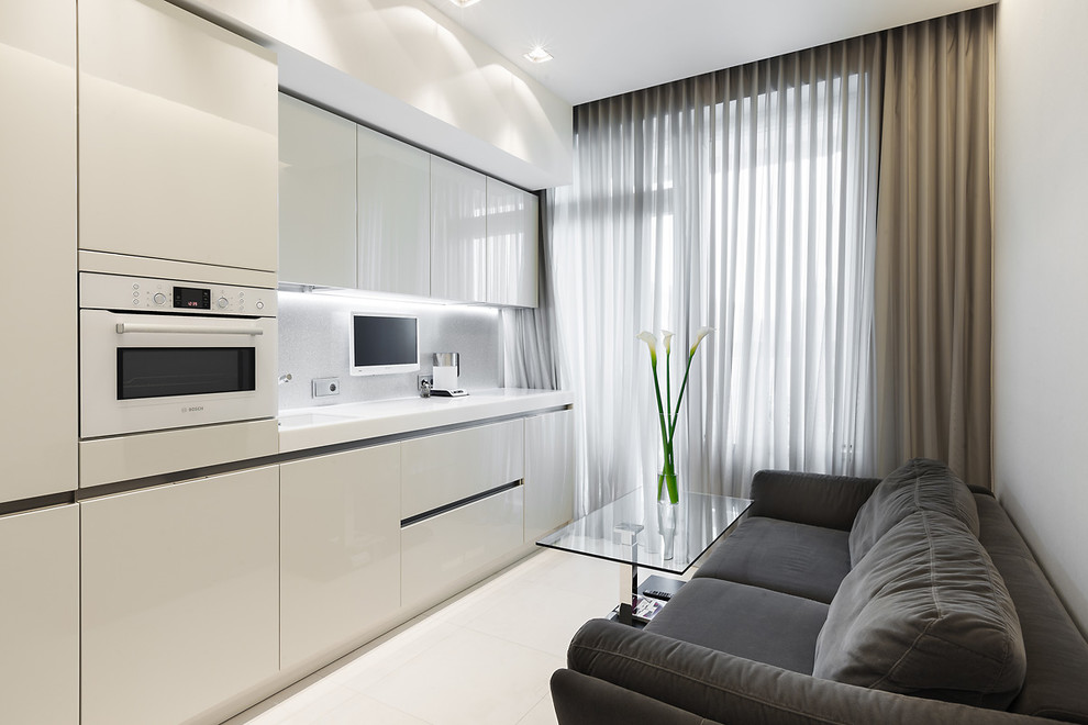 Immagine di una cucina lineare minimal chiusa con lavello sottopiano, ante lisce, ante bianche, paraspruzzi bianco e elettrodomestici bianchi