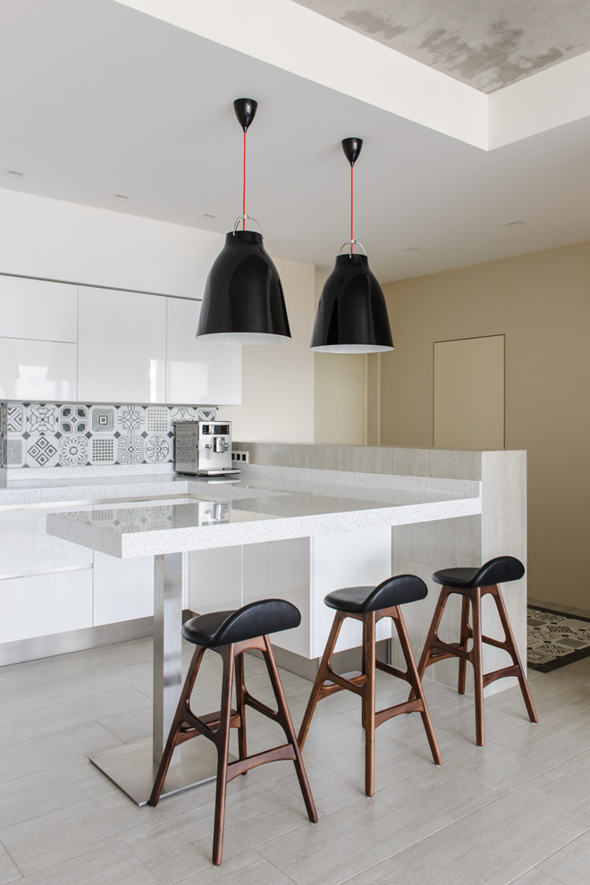 This is an example of a scandi open plan kitchen in Other with flat-panel cabinets, white cabinets, a breakfast bar, grey splashback and grey floors.