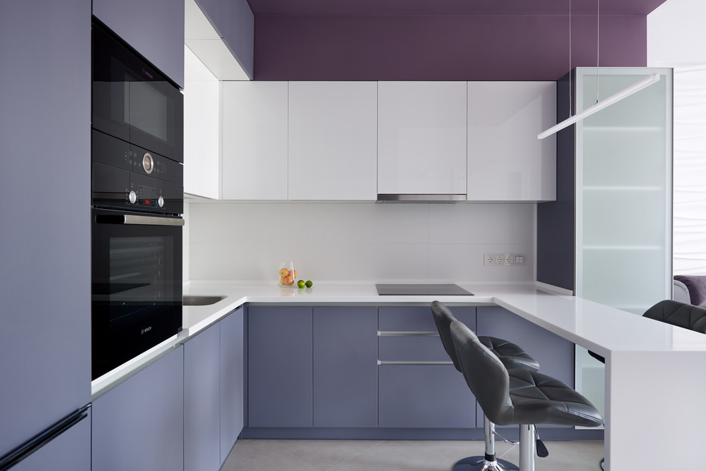 Стильный дизайн: п-образная кухня среднего размера в современном стиле с одинарной мойкой, плоскими фасадами, фиолетовыми фасадами, белым фартуком, черной техникой, полуостровом, серым полом, белой столешницей и двухцветным гарнитуром - последний тренд