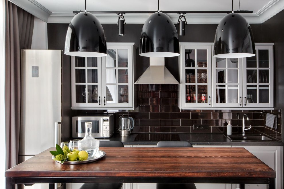 Inspiration för ett mellanstort vintage linjärt kök med öppen planlösning, med en enkel diskho, svart stänkskydd, rostfria vitvaror, luckor med upphöjd panel, grå skåp, stänkskydd i keramik, klinkergolv i porslin och svart golv