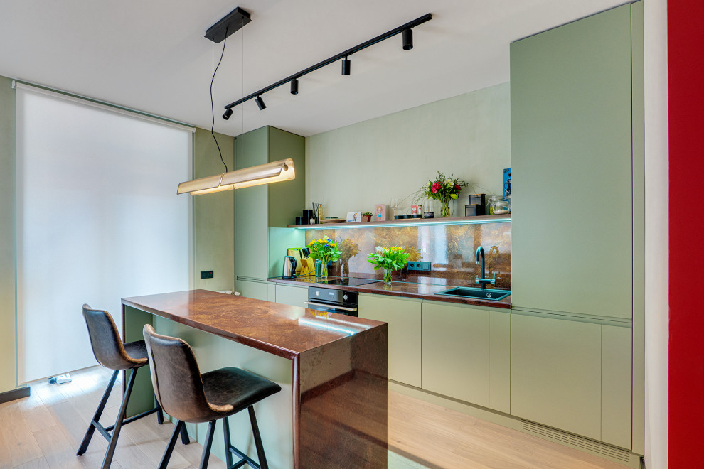 This is an example of a contemporary single-wall kitchen in Moscow with a built-in sink, flat-panel cabinets, green cabinets, brown splashback, black appliances, an island, beige floors and brown worktops.