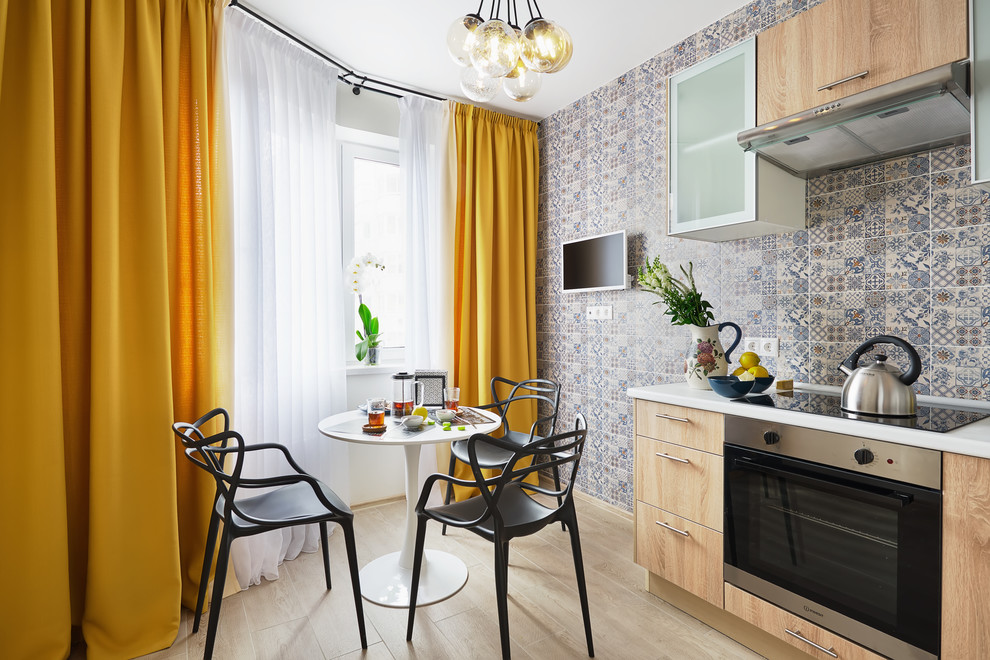 Immagine di una cucina a L minimal chiusa con ante lisce, ante in legno chiaro, paraspruzzi grigio, parquet chiaro, nessuna isola, pavimento beige e top bianco