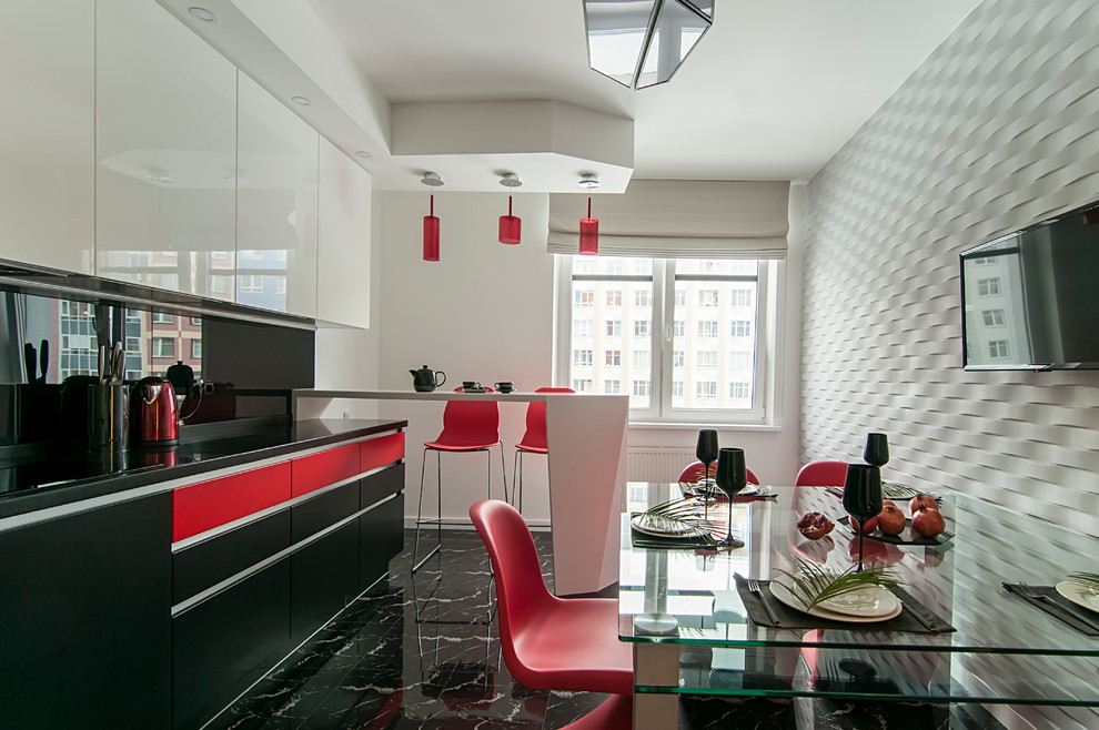 На фото: кухня в современном стиле с обеденным столом, плоскими фасадами, красными фасадами, черным фартуком, фартуком из стекла, мраморным полом, полуостровом, черным полом и черной столешницей с