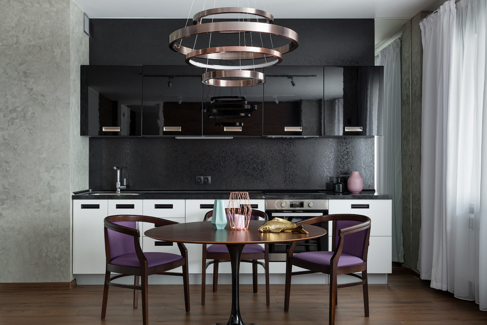 This is an example of a contemporary single-wall kitchen/diner in Moscow with a submerged sink, flat-panel cabinets, black cabinets, black splashback, stainless steel appliances, no island, brown floors and black worktops.
