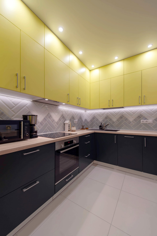 サンクトペテルブルクにある低価格の小さなコンテンポラリースタイルのおしゃれなキッチン (シングルシンク、シルバーの調理設備、磁器タイルの床) の写真