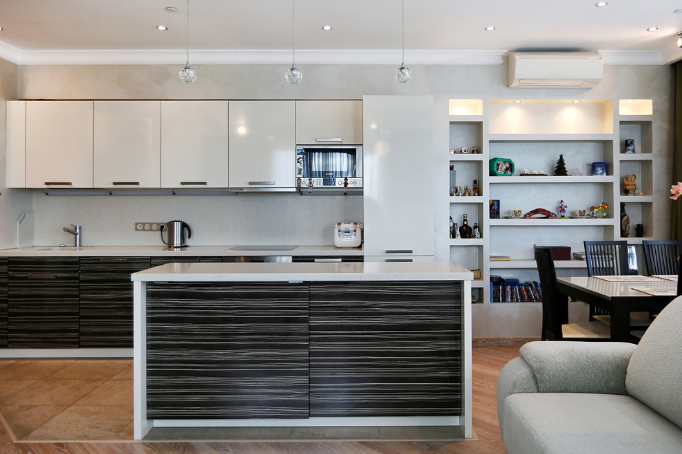 Foto på ett funkis kök med öppen planlösning, med en enkel diskho, släta luckor, rostfria vitvaror, en köksö och grått stänkskydd