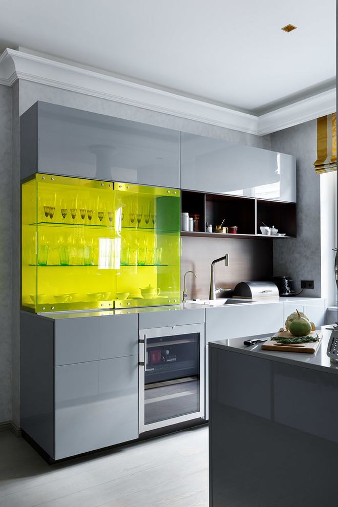 Diseño de cocina actual abierta con fregadero encastrado, armarios con paneles lisos y puertas de armario grises