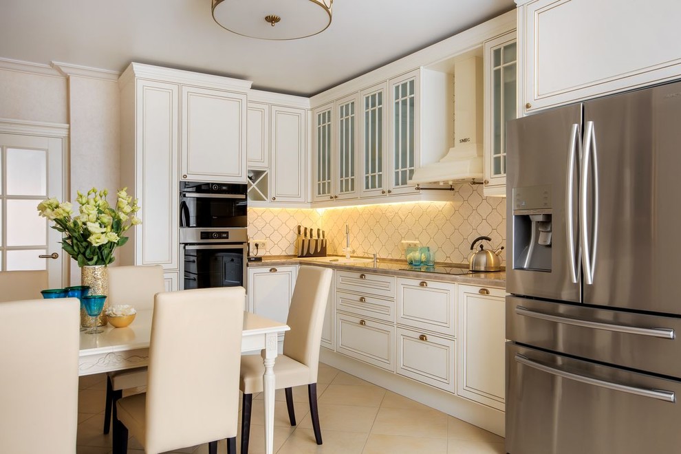 Photo of a medium sized traditional l-shaped enclosed kitchen in Other with beige splashback, ceramic splashback, stainless steel appliances, porcelain flooring, beige floors, a built-in sink, white cabinets and no island.