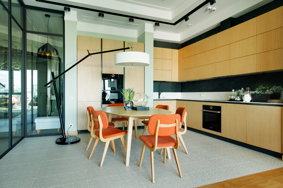 Пример оригинального дизайна: угловая кухня-гостиная в современном стиле с плоскими фасадами, фасадами цвета дерева среднего тона и черной техникой без острова