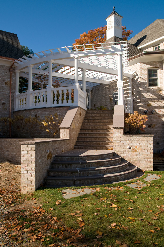 This is an example of an expansive traditional back partial sun garden for autumn in Boston with brick paving.