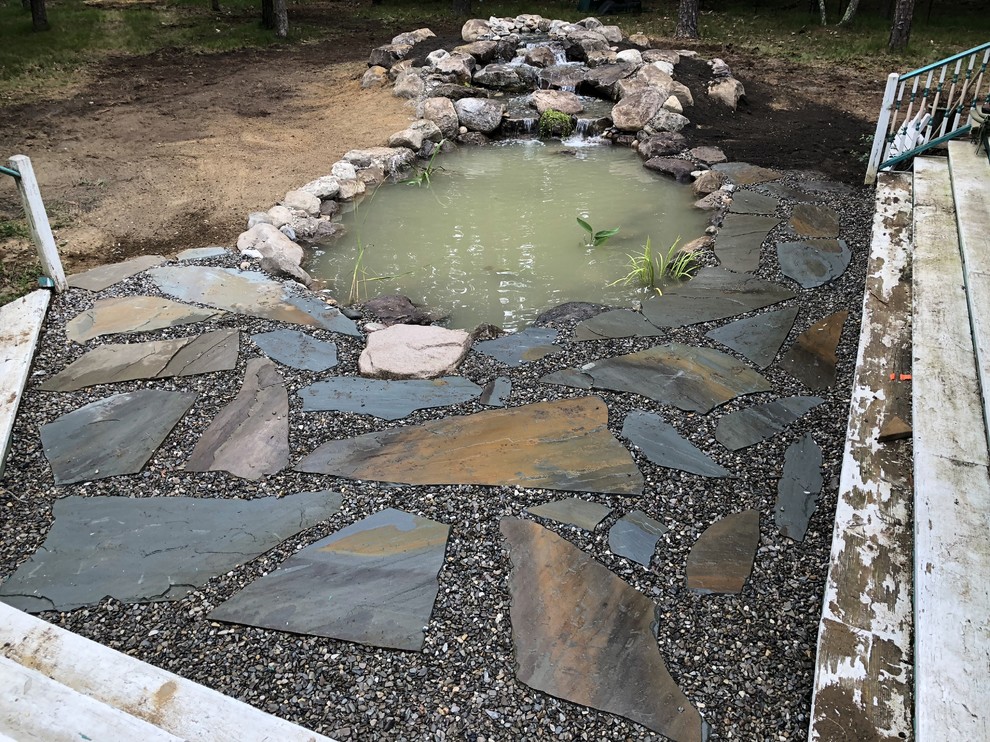 Inspiration for a large traditional back partial sun garden for summer in Philadelphia with a pond and natural stone paving.