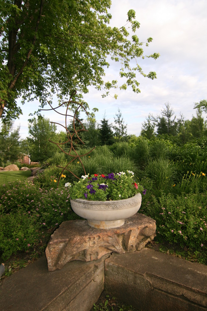 Foto de jardín de estilo de casa de campo extra grande en patio delantero con jardín francés, jardín de macetas, exposición parcial al sol y adoquines de piedra natural