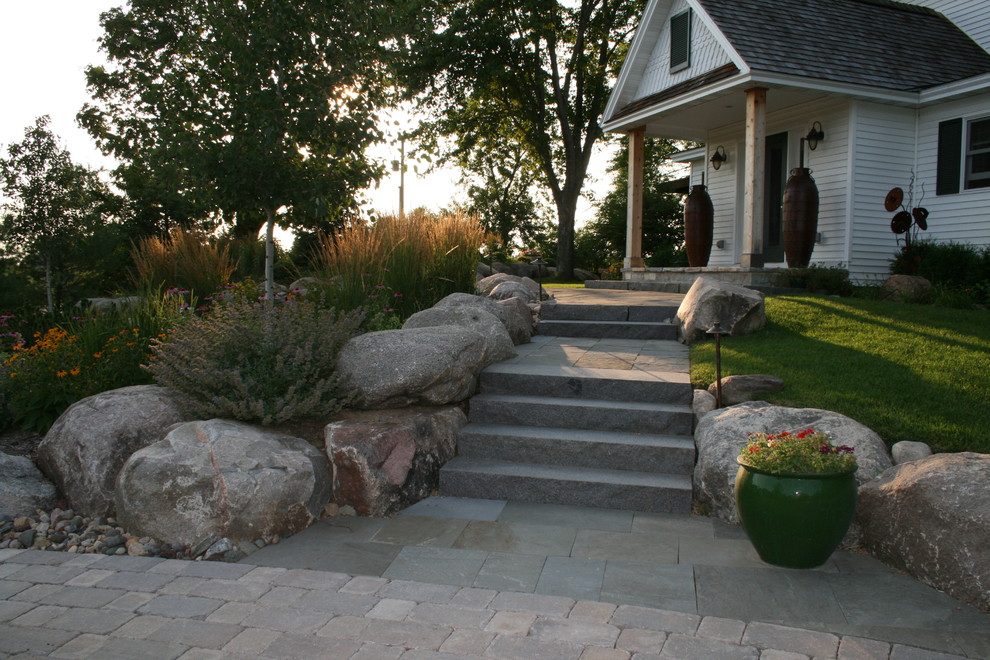 Foto di un ampio vialetto d'ingresso country esposto a mezz'ombra davanti casa con un ingresso o sentiero e pavimentazioni in pietra naturale