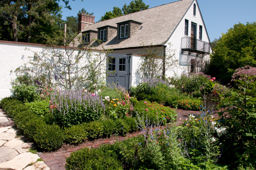 Cette image montre un jardin à la française latéral traditionnel avec une exposition ensoleillée et des pavés en brique.