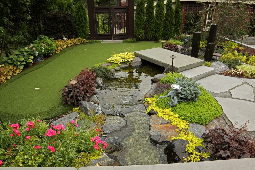 Esempio di un grande giardino classico esposto in pieno sole davanti casa in estate con fontane e pavimentazioni in mattoni