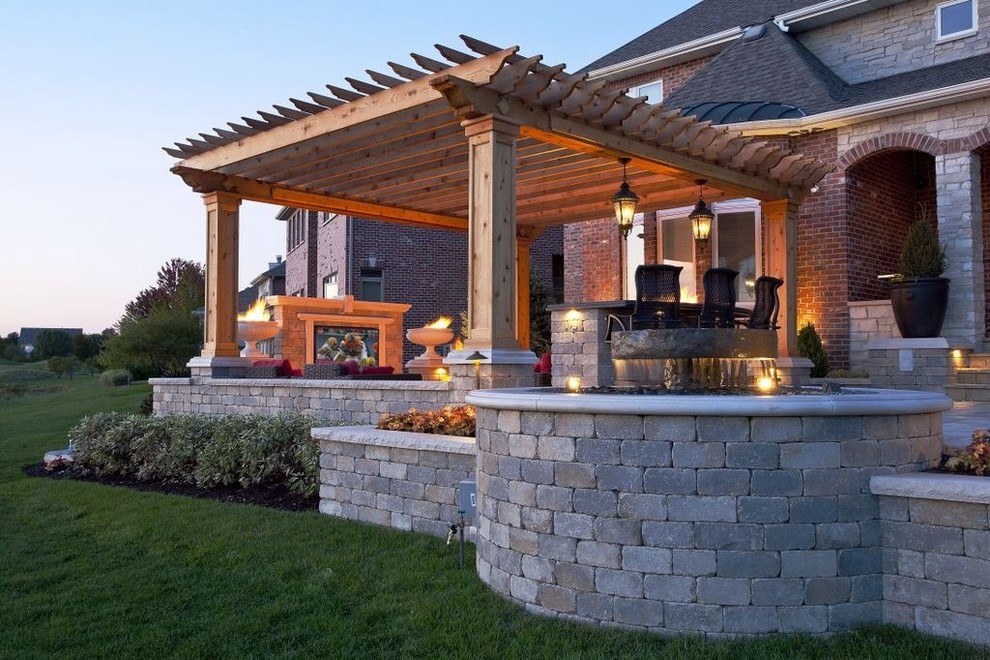 Diseño de patio clásico grande en patio trasero con fuente y adoquines de ladrillo