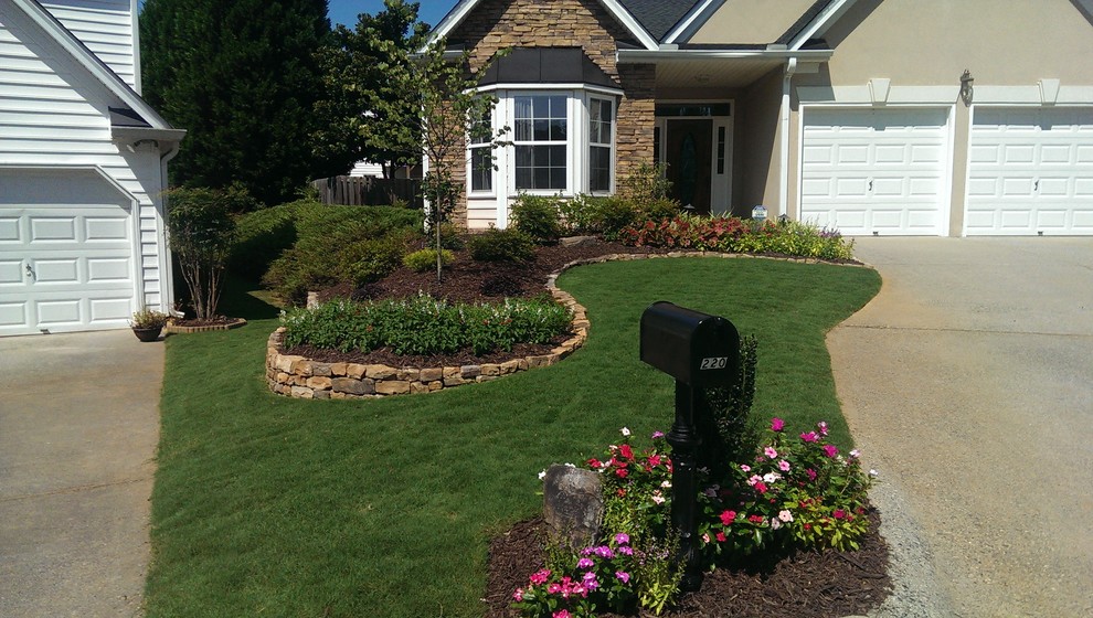 Modelo de jardín de estilo americano en patio delantero con muro de contención y adoquines de piedra natural