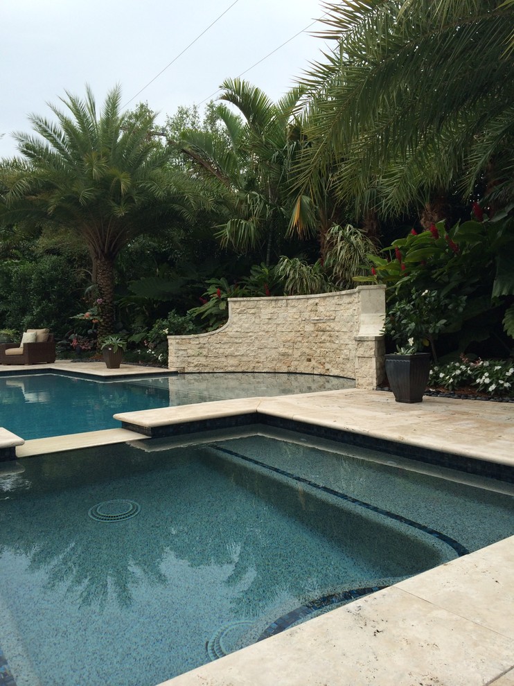 Idées déco pour une grande piscine latérale exotique avec des pavés en pierre naturelle.