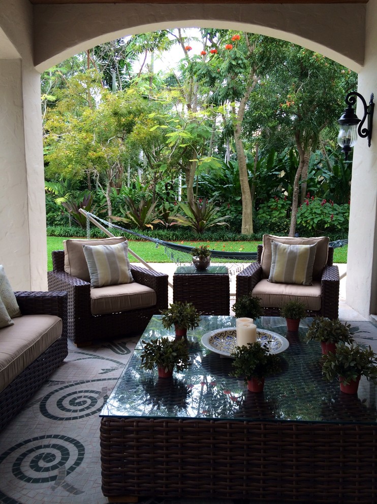 Idee per un grande patio o portico tropicale dietro casa con pavimentazioni in pietra naturale