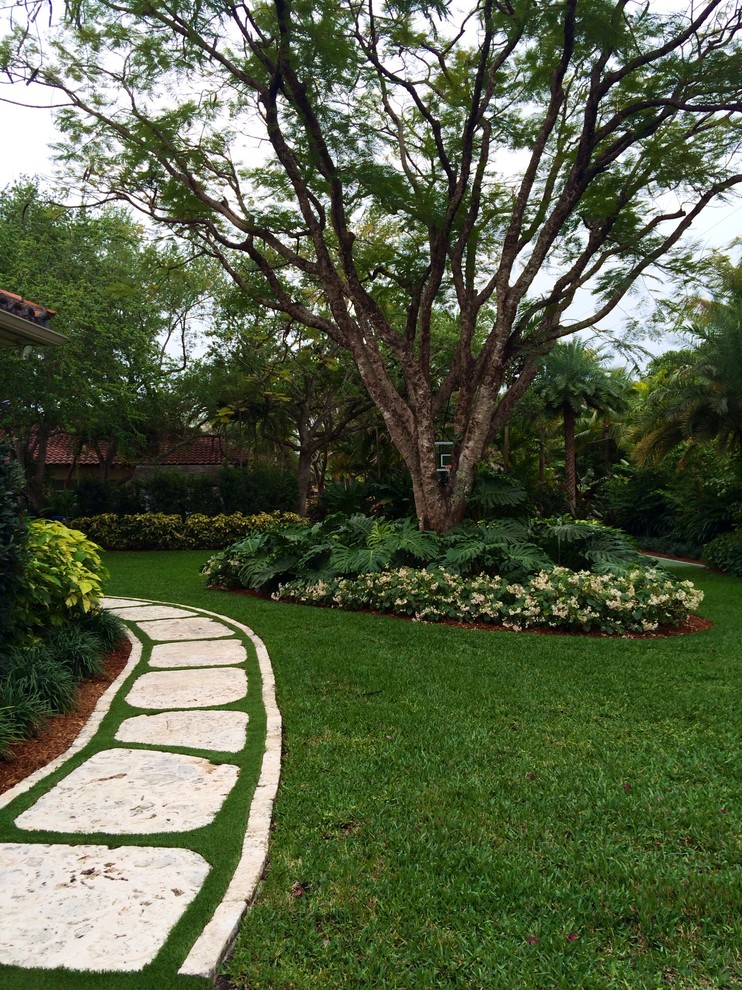 Großer, Halbschattiger Gartenweg im Sommer, neben dem Haus mit Natursteinplatten in Miami