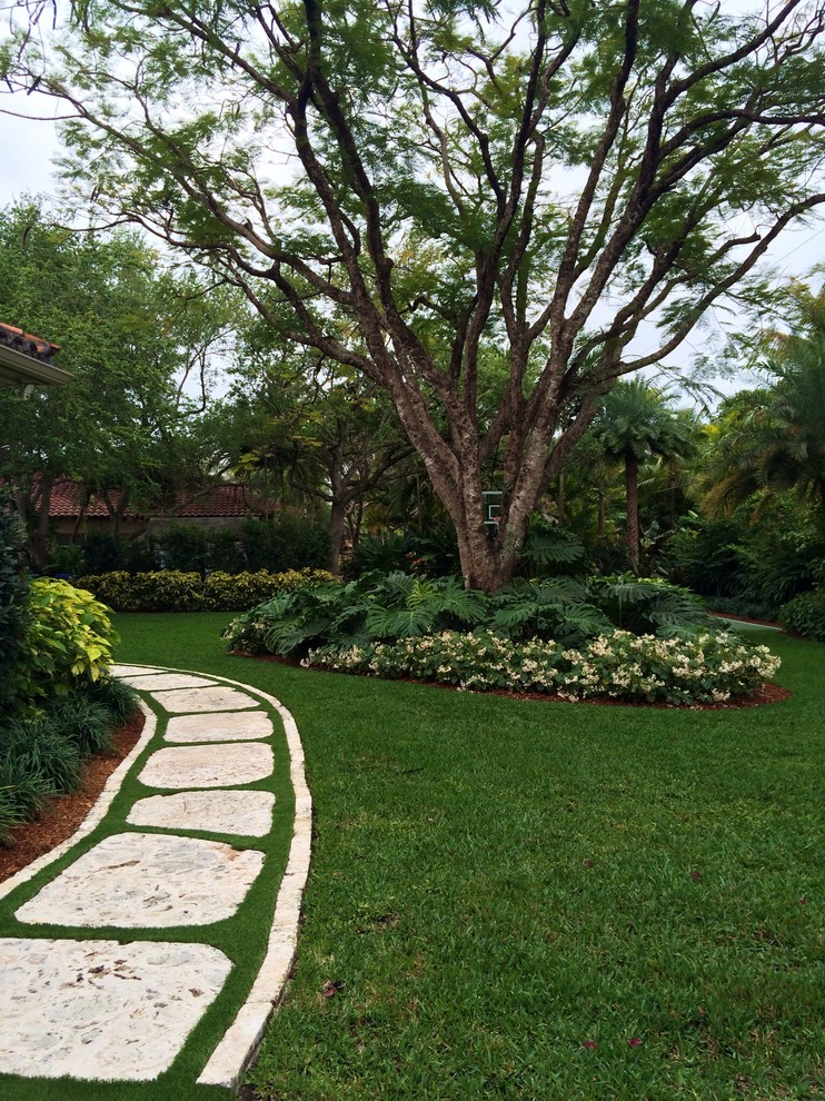 Idee per un grande giardino tropicale esposto a mezz'ombra nel cortile laterale in estate con un ingresso o sentiero e pavimentazioni in pietra naturale