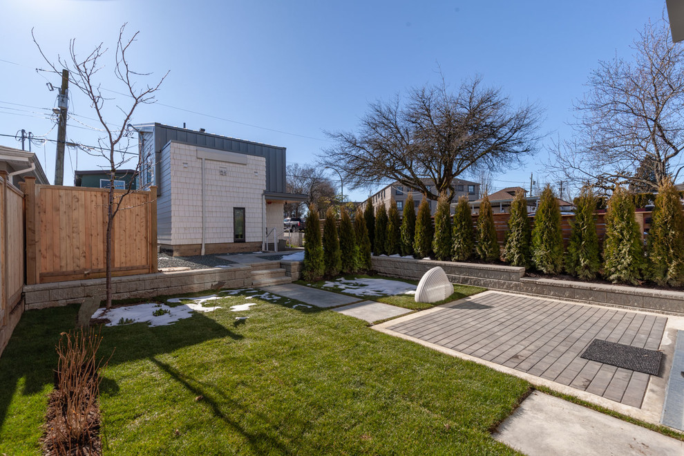 Foto di un giardino formale contemporaneo esposto in pieno sole di medie dimensioni e dietro casa in primavera con un muro di contenimento e pavimentazioni in mattoni