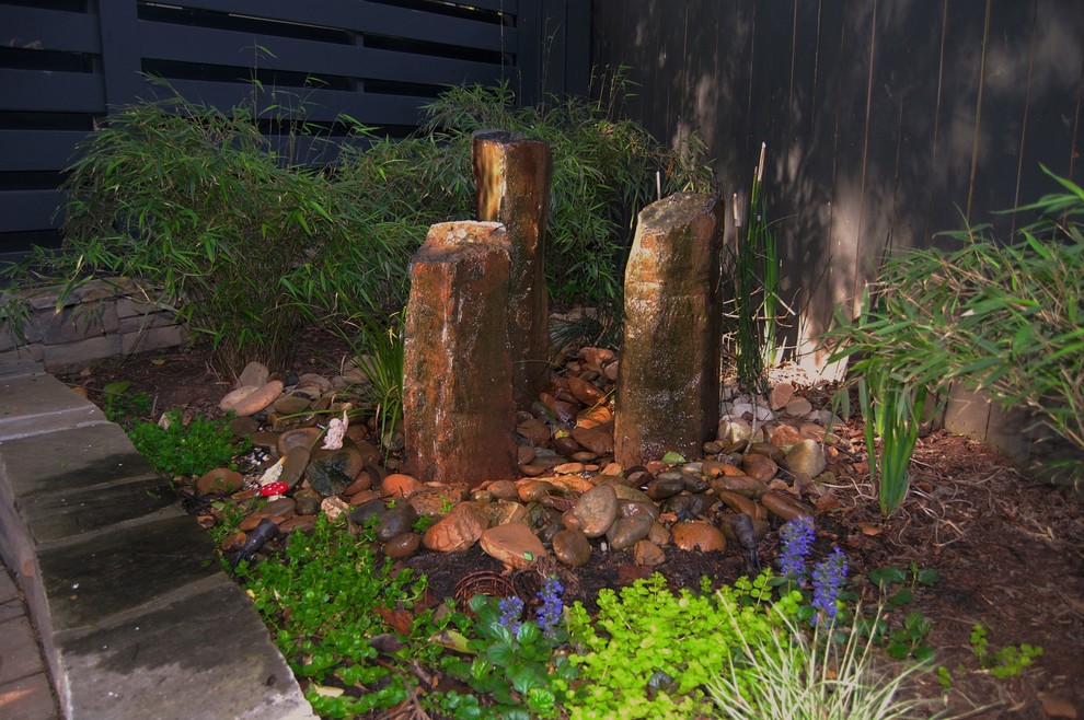 Foto de jardín de estilo americano en patio trasero con fuente, exposición parcial al sol y adoquines de piedra natural