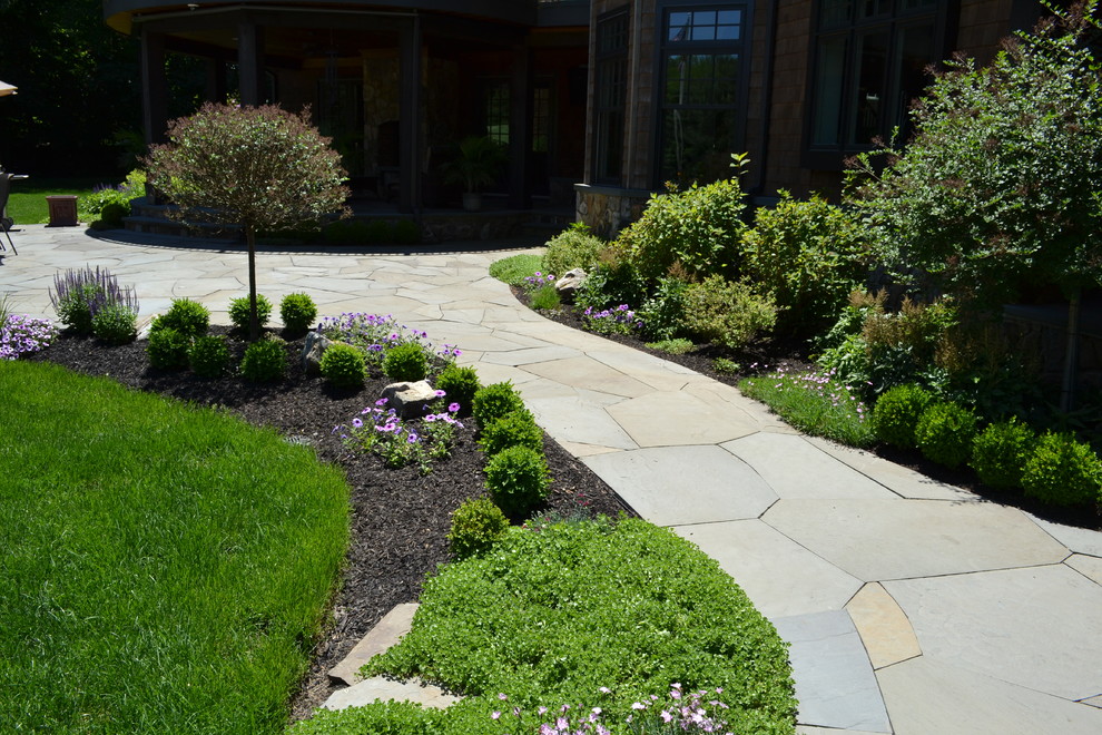 Cette image montre un grand jardin arrière minimaliste l'été avec une exposition ensoleillée et des pavés en pierre naturelle.