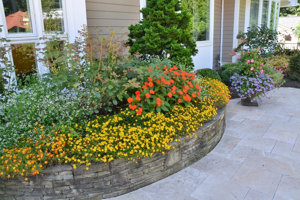 Design ideas for a large world-inspired back formal partial sun garden in New York with a retaining wall and natural stone paving.