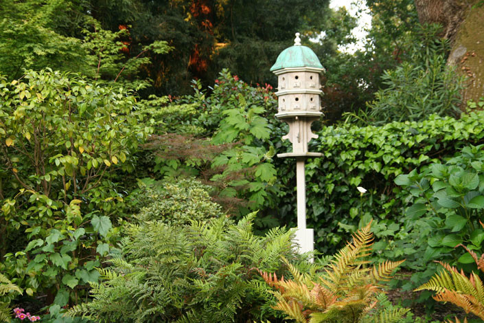 На фото: огромный весенний регулярный сад на боковом дворе в классическом стиле с садовой дорожкой или калиткой, полуденной тенью и мощением клинкерной брусчаткой с