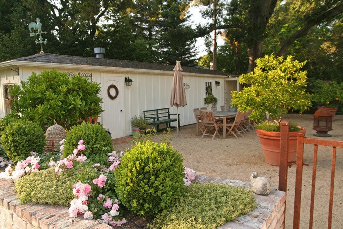 Foto di un ampio giardino formale tradizionale esposto a mezz'ombra dietro casa in primavera con ghiaia e un giardino in vaso