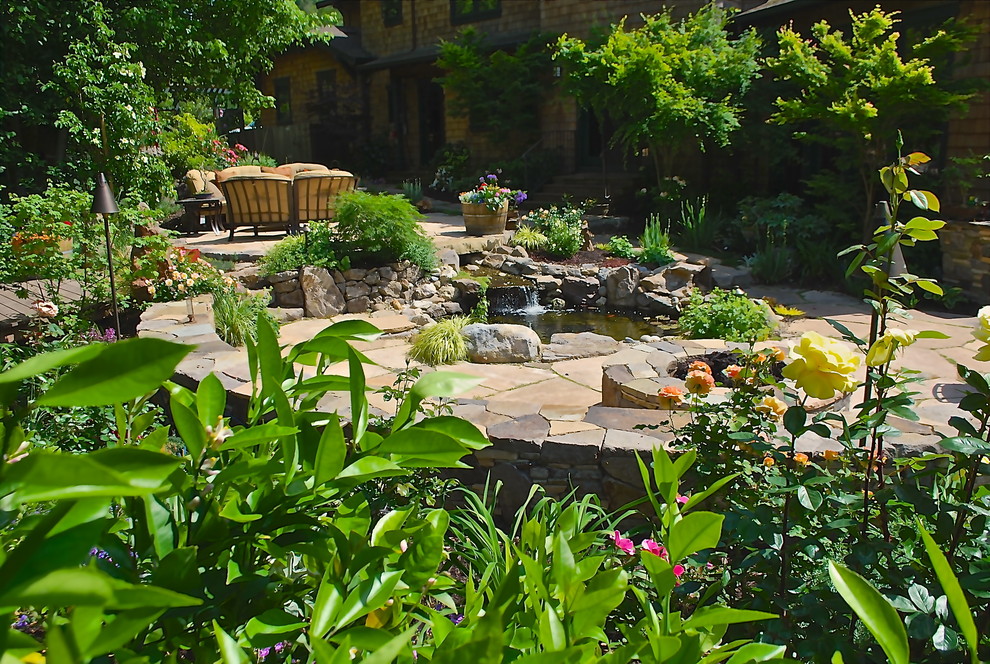 Exemple d'un jardin arrière chic de taille moyenne et au printemps avec un point d'eau, une exposition ensoleillée et des pavés en pierre naturelle.