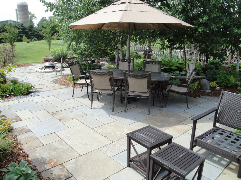 Inspiration for a huge timeless backyard stone patio remodel in Milwaukee