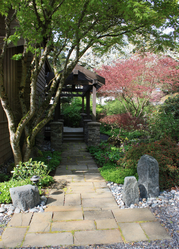 This is an example of a mid-sized rustic full sun front yard stone landscaping in Seattle.