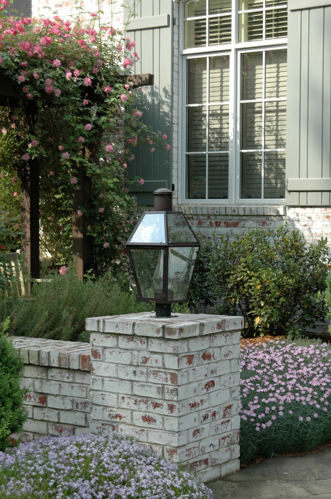 Modelo de jardín clásico de tamaño medio en patio delantero con jardín francés y adoquines de piedra natural